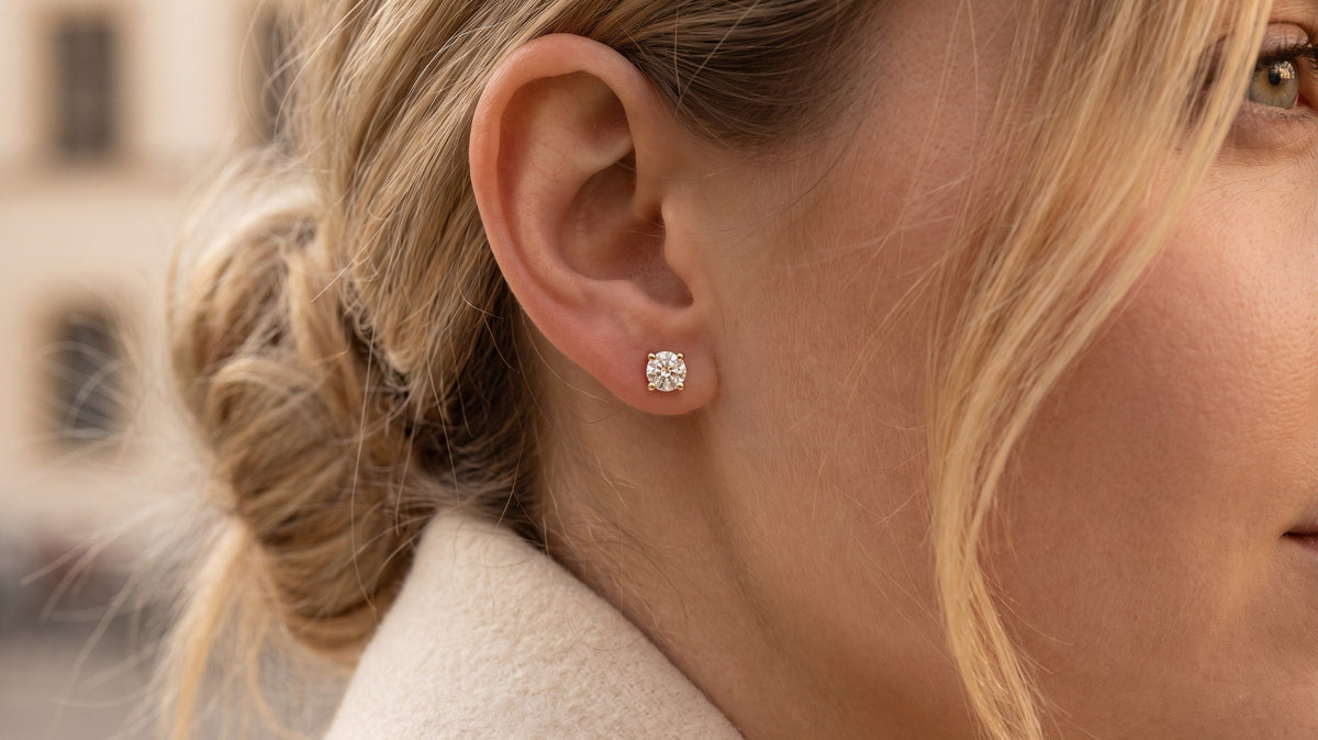 Diamant-Ohrstecker mit Labordiamant in Gelbgold am Ohr, im Winterlicht